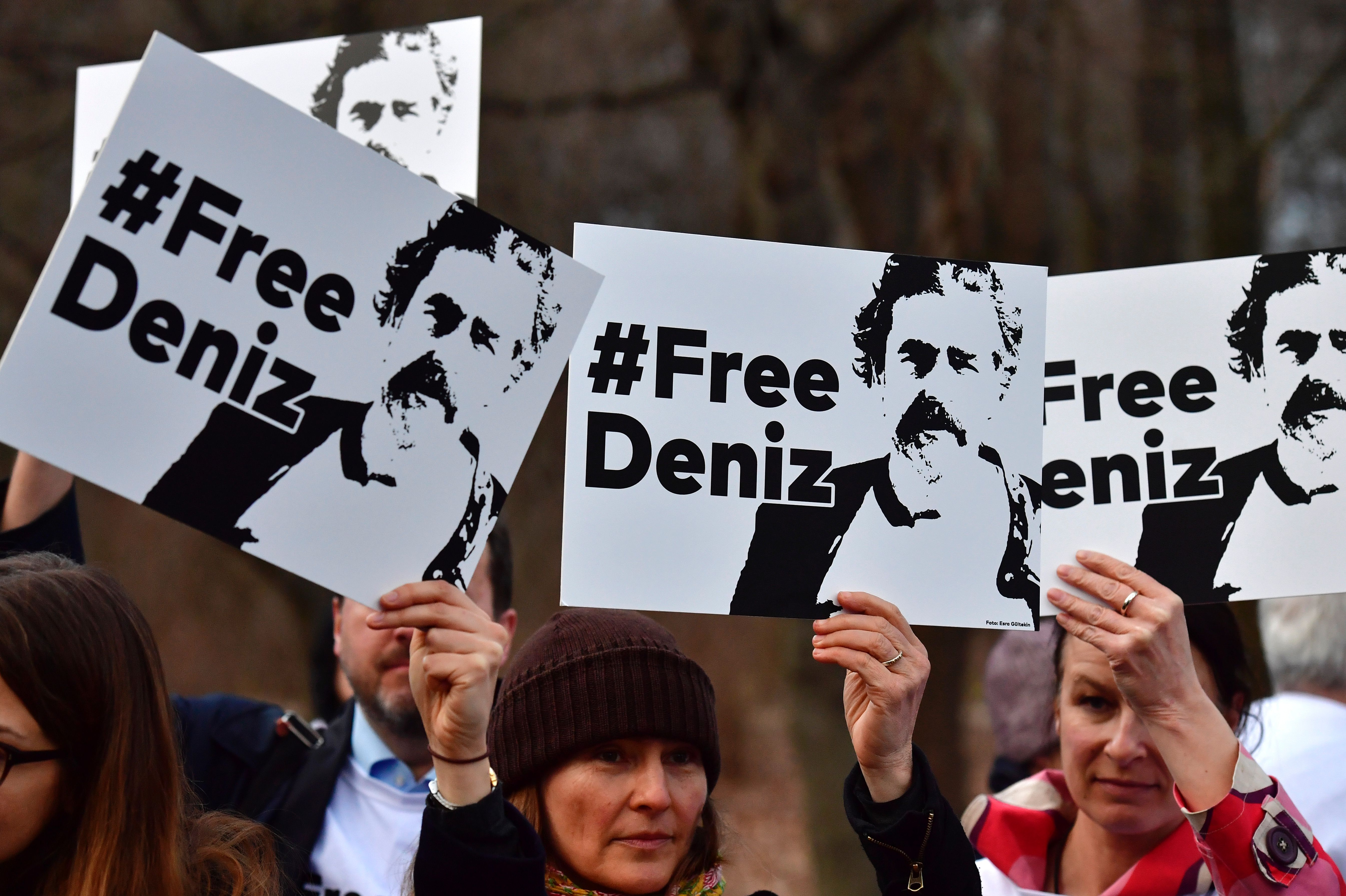 People hold placards with hashtag #FREEDENIZ to protest the detantion of German journalist Deniz Yucel in front of Turkish embassy in Berlin on February 28, 2017. 
The investigative detention against Yuecel in Turkey has sparked indignation in the government, parties, and journalist associations in Germany. Yucel, 43, was detained on February 18 and his apartment searched in connection with news reports on an attack by hackers on the email account of Turkey's energy minister. Yucel originates from Floersheim. / AFP / John MACDOUGALL        (Photo credit should read JOHN MACDOUGALL/AFP/Getty Images)